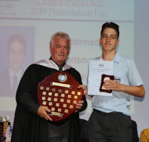 Max receiving an award from his school